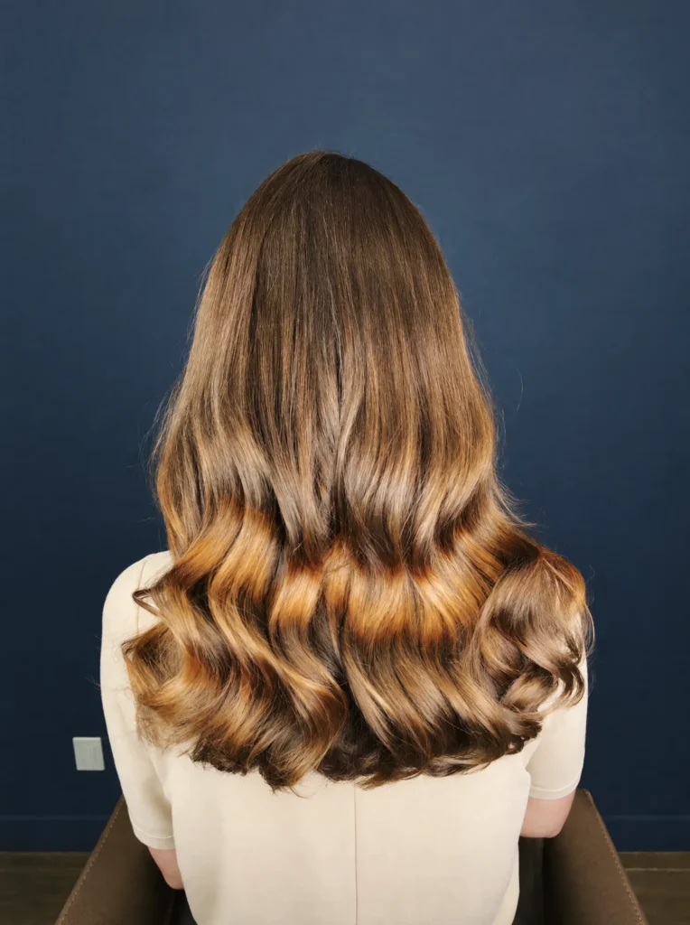 After: the same hair with soft caramel and honey balayage