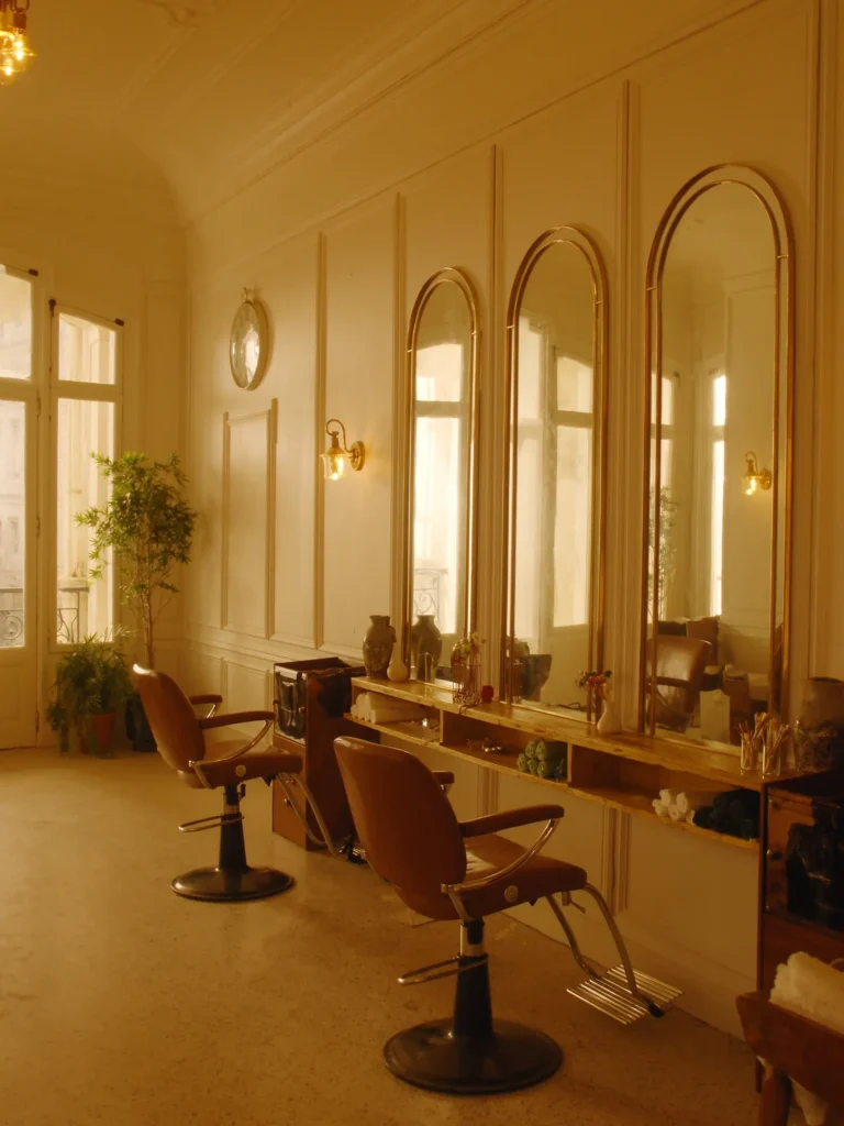 Het interieur van de salon met boogspiegels en cognackleurige stoelen in de ochtendzon
