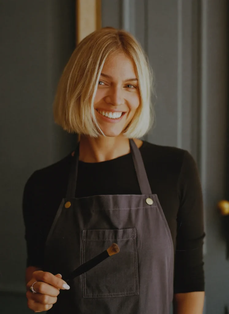 Portret van kleurspecialist Sanne Verhoeven met een kleurkwast